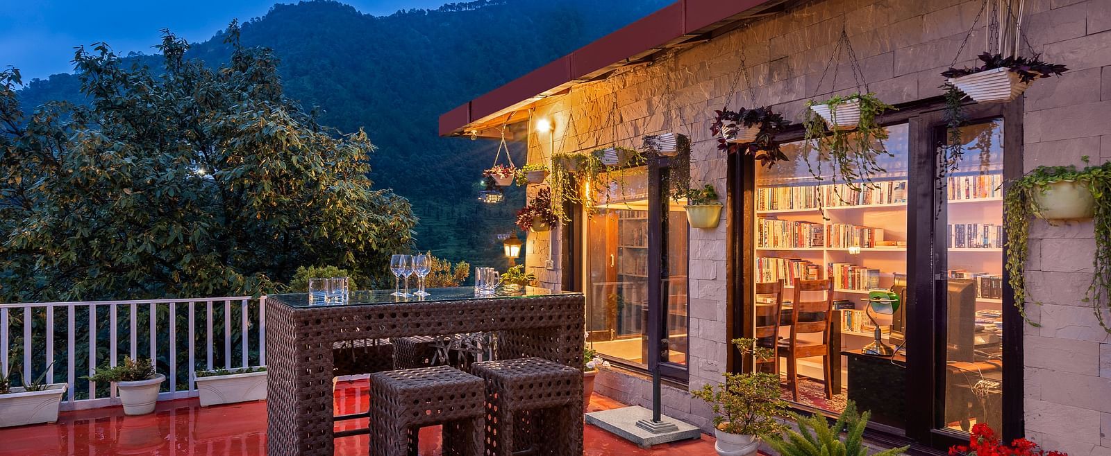 Cosy outdoor patio and a library, set against a mountain backdrop at dusk, at BluSalzz Collection - Suvaasa Resort, Ramgarh.