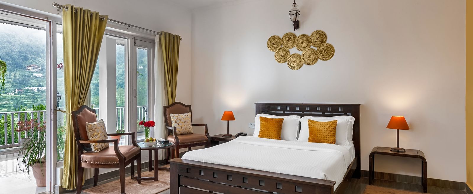 Spacious bedroom with large bed, seating area, and balcony access, at BluSalzz Collection - Suvaasa Resort, Ramgarh.