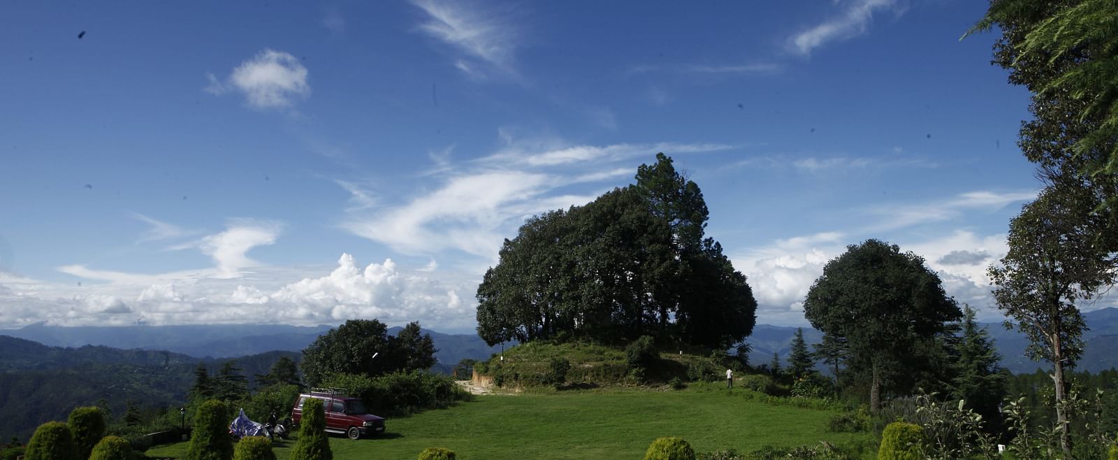 A vibrant wedding lawn in Almora with a scenic backdrop of hills and trees - BluSalzz Escapade - Anant Rasa Resort