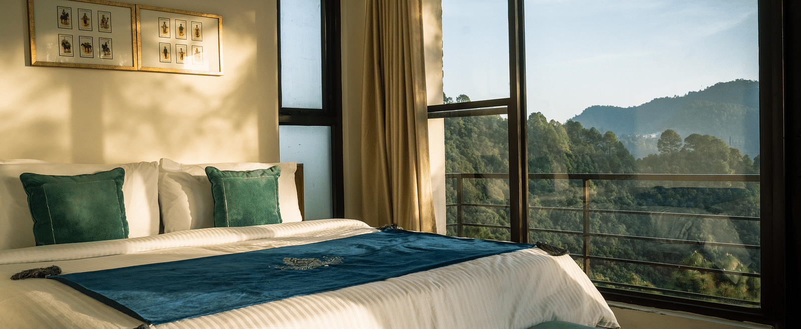 A bedroom with a balcony offering a mountain view and sunlight streaming in at BluSalzz Escapade Resort, Lansdowne