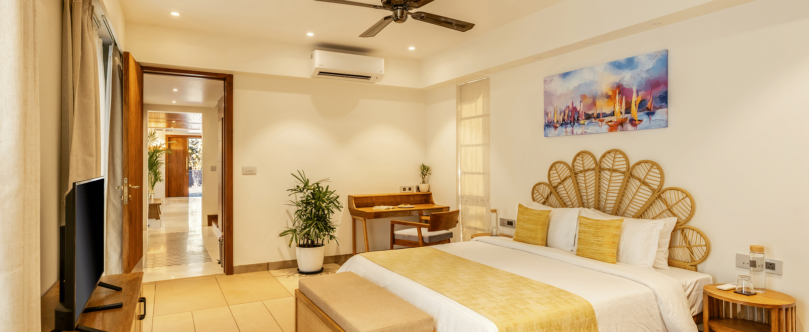 A luxurious bedroom with a king-sized bed, ornate wooden headboards, and complementary beige and yellow decor - BluSalzz Villas - Alocassia, Anjuna