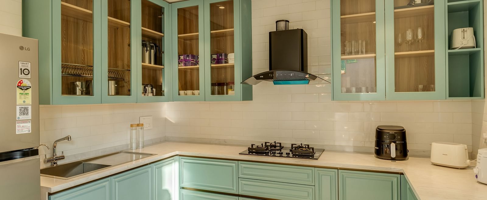 A sleek kitchen with pastel-coloured cabinets, integrated appliances, and a bright, airy ambience.