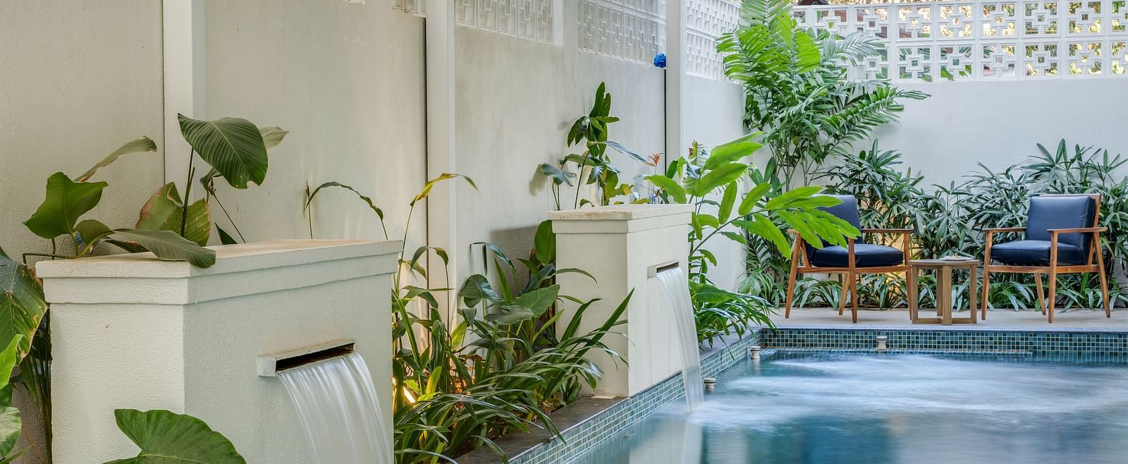 A corner view of a pool with a seating area surrounded by greenery, perfect for relaxation - BluSalzz Villas - Alocassia, Anjuna