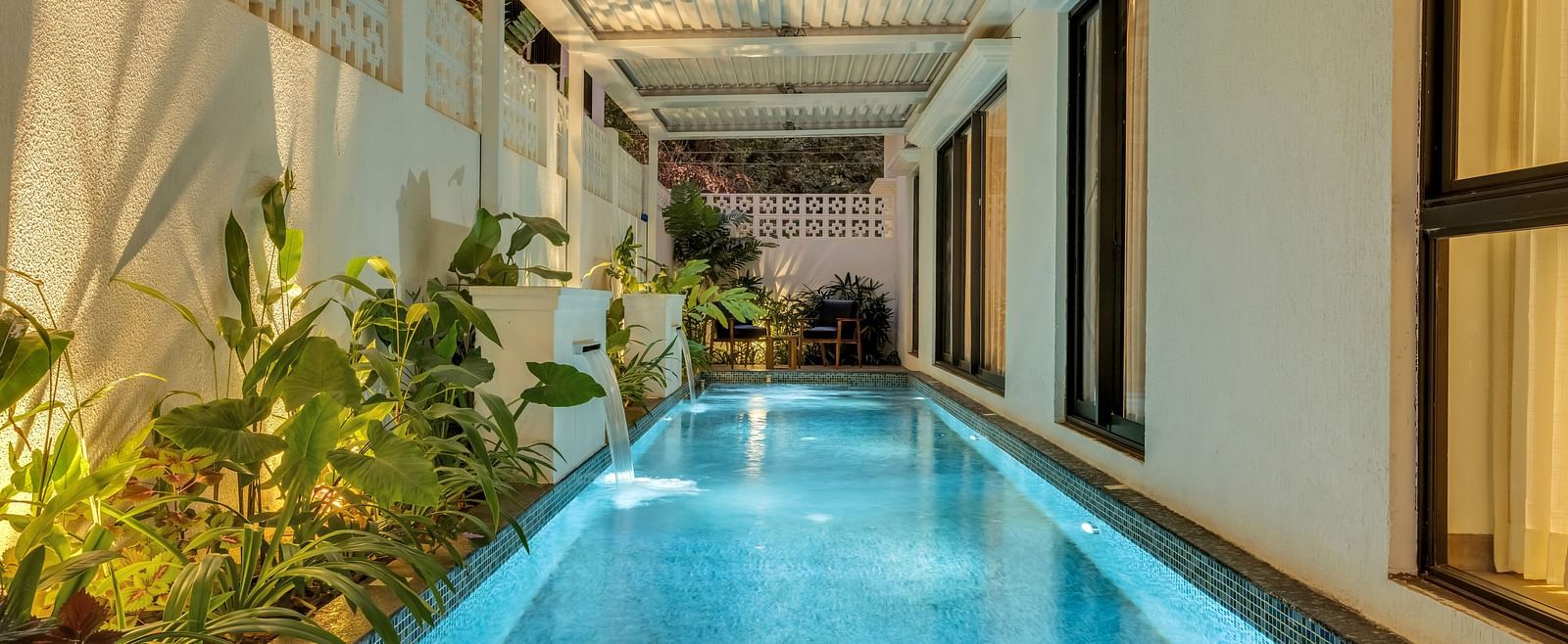 A serene swimming pool running alongside the villa, surrounded by lush greenery and modern architectural elements - BluSalzz Villas - Alocassia, Anjuna