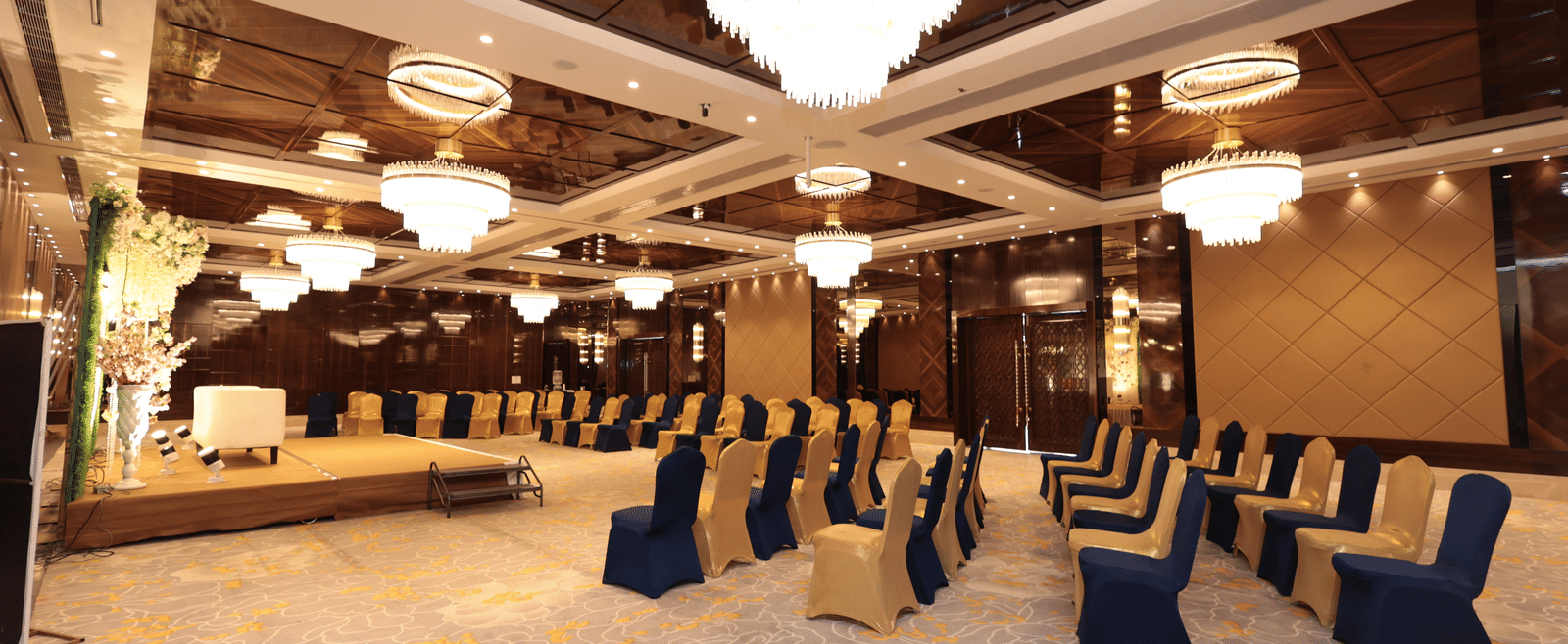 A side view of a banquet hall with chairs arranged around the stage area | Cenneys Gateway