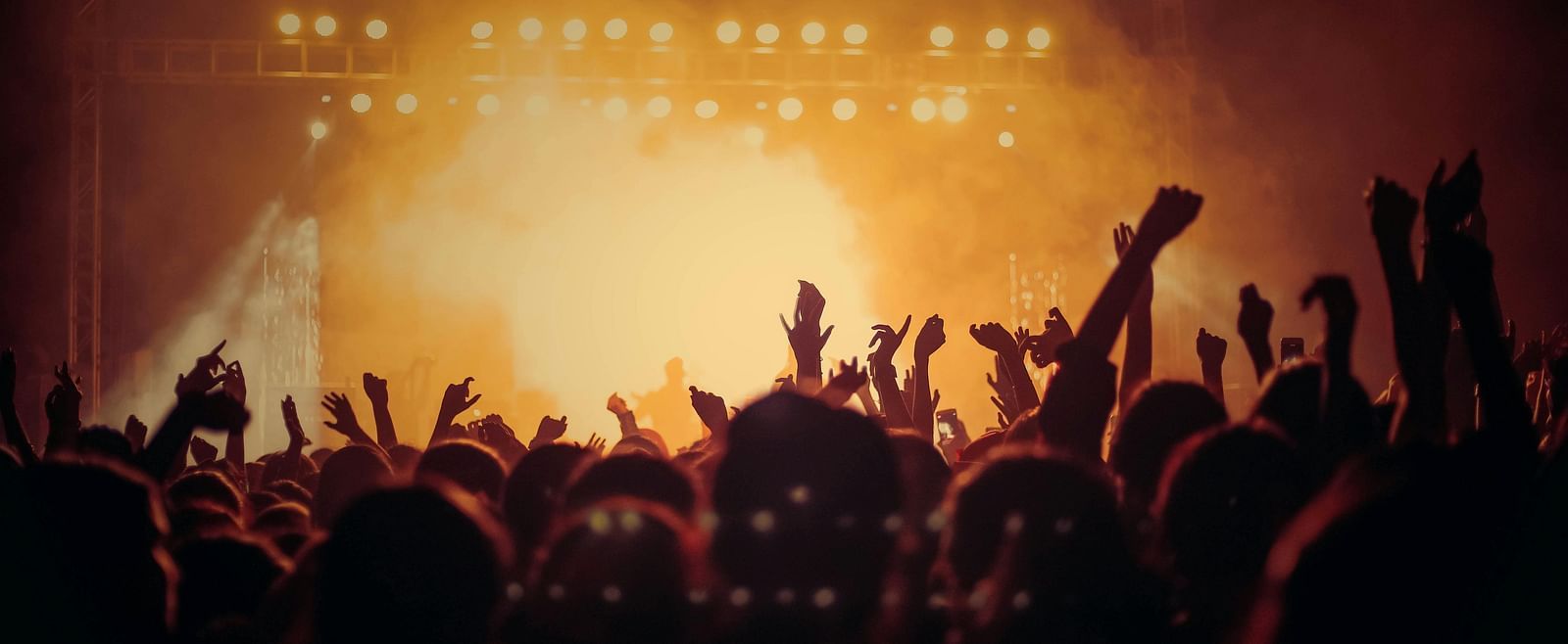 A crowd dancing under colourful lights.