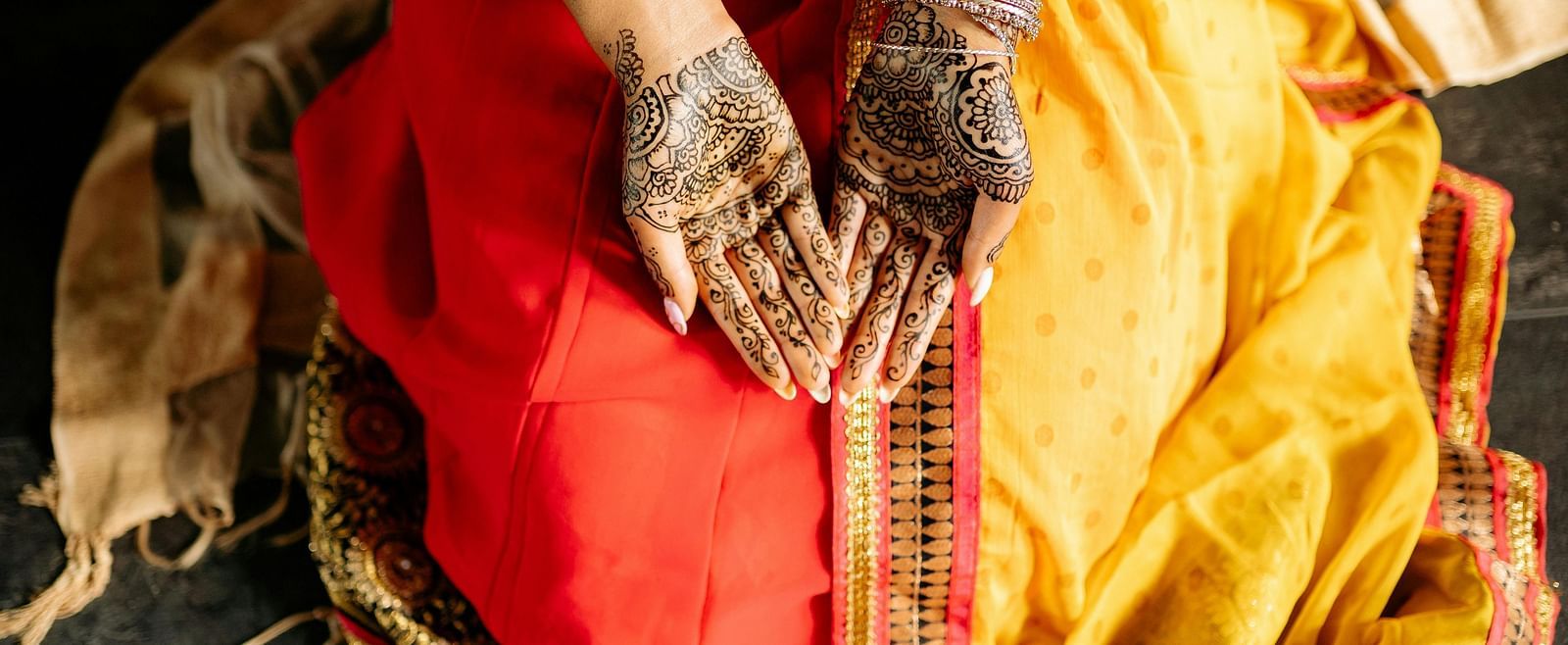 a woman with her palms open showing her mehendi on her hands