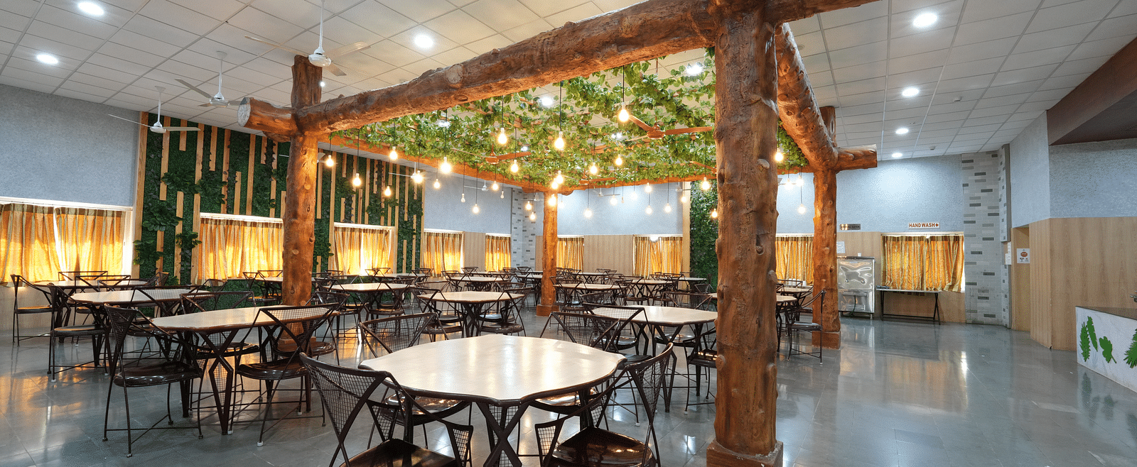 Dining tables and chairs placed in Greens Inn Restaurant - Fine Dining in Hyderabad.