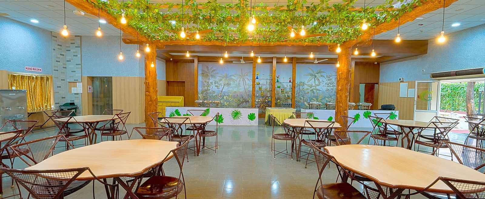 Dining tables and chairs placed in Greens Inn Restaurant - Top Restaurant in Hyderabad.