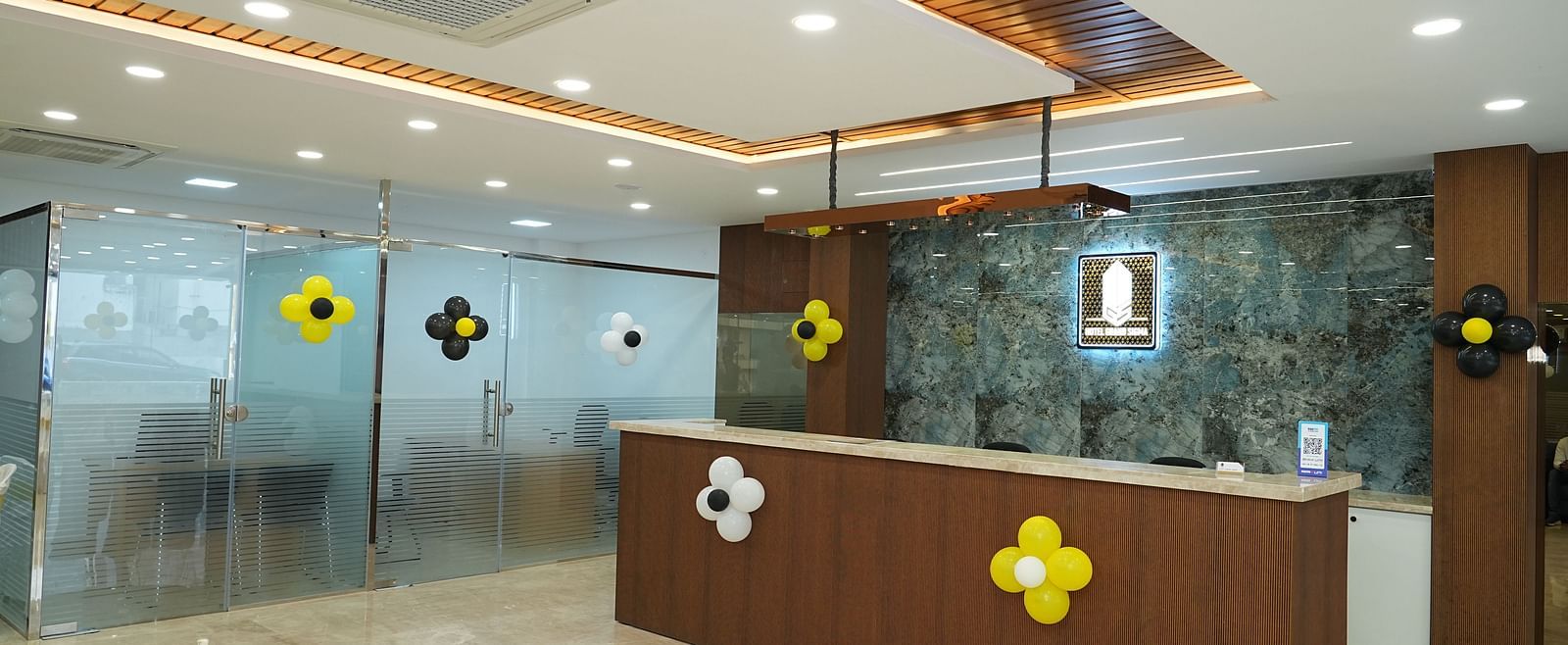 corner view image of the reception area with the logo of the hotel illuminated behind the desk - Hotel Grand Sigma