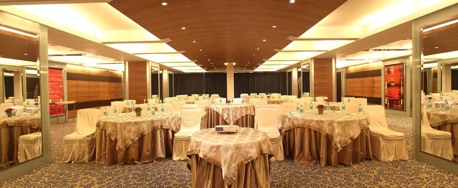 Image of Amber hall at Mirage featuring a stylish decor with brown round tables and chairs | Mirage Hotel