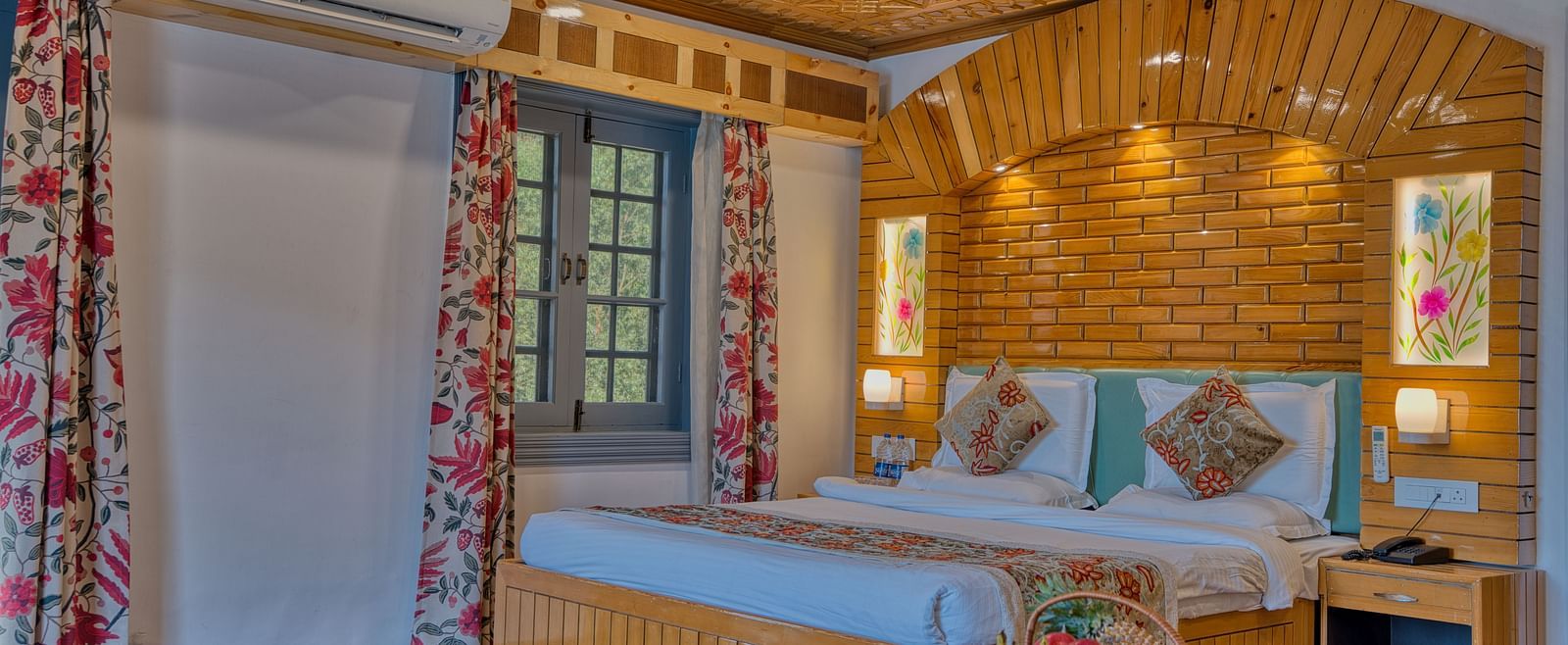 Tastefully designed guest room with wooden textures and natural tones at Royal Comfort Regency, ideal for restful nights.