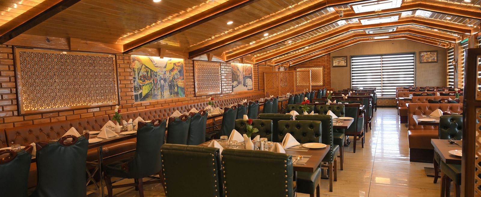 Spacious dining hall with plush seating and ambient lighting at Royal Comfort Regency, ideal for group dining and gatherings.