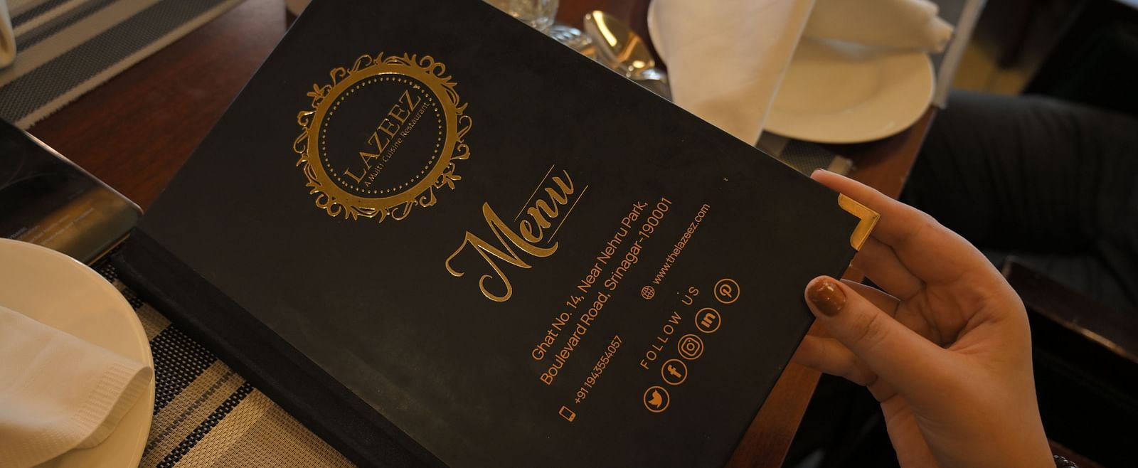 Guest holding the menu at Royal Comfort Regency highlighting a curated selection of dishes for a premium dining experience.