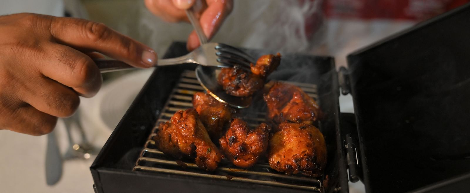 Chef grilling fresh tandoori delicacies live at Royal Comfort Regency, bringing authentic flavours straight to your table.