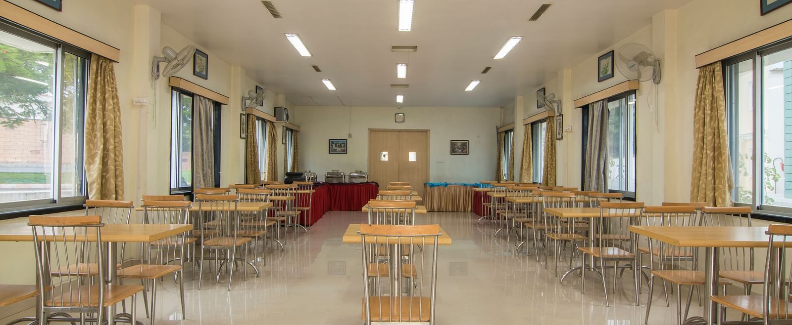 Another view of the same conference room, with a focus on the seating arrangement and lighting fixtures at Shantiniketan - Budget Stay in Hyderabad near Ramoji Film City.