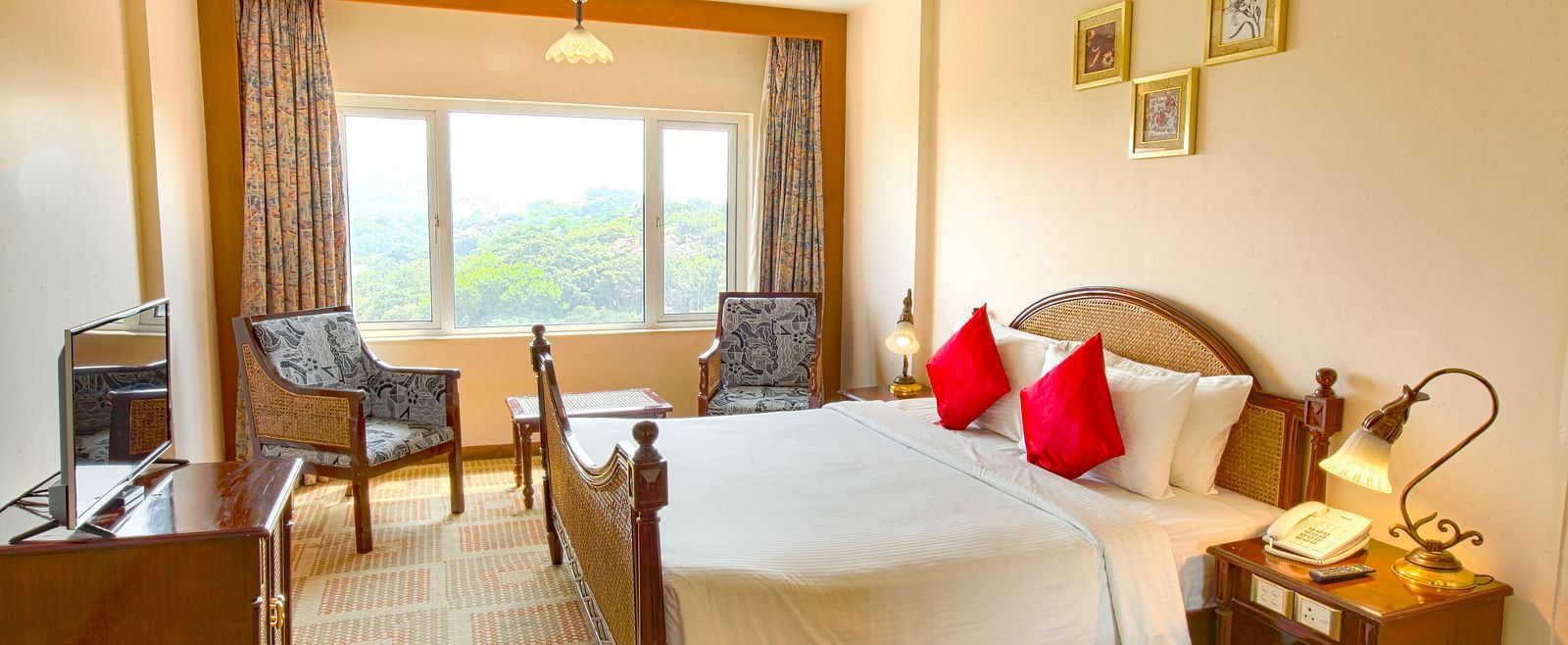 A cozy hotel room with a large window, offering a scenic view and featuring modern furnishings.