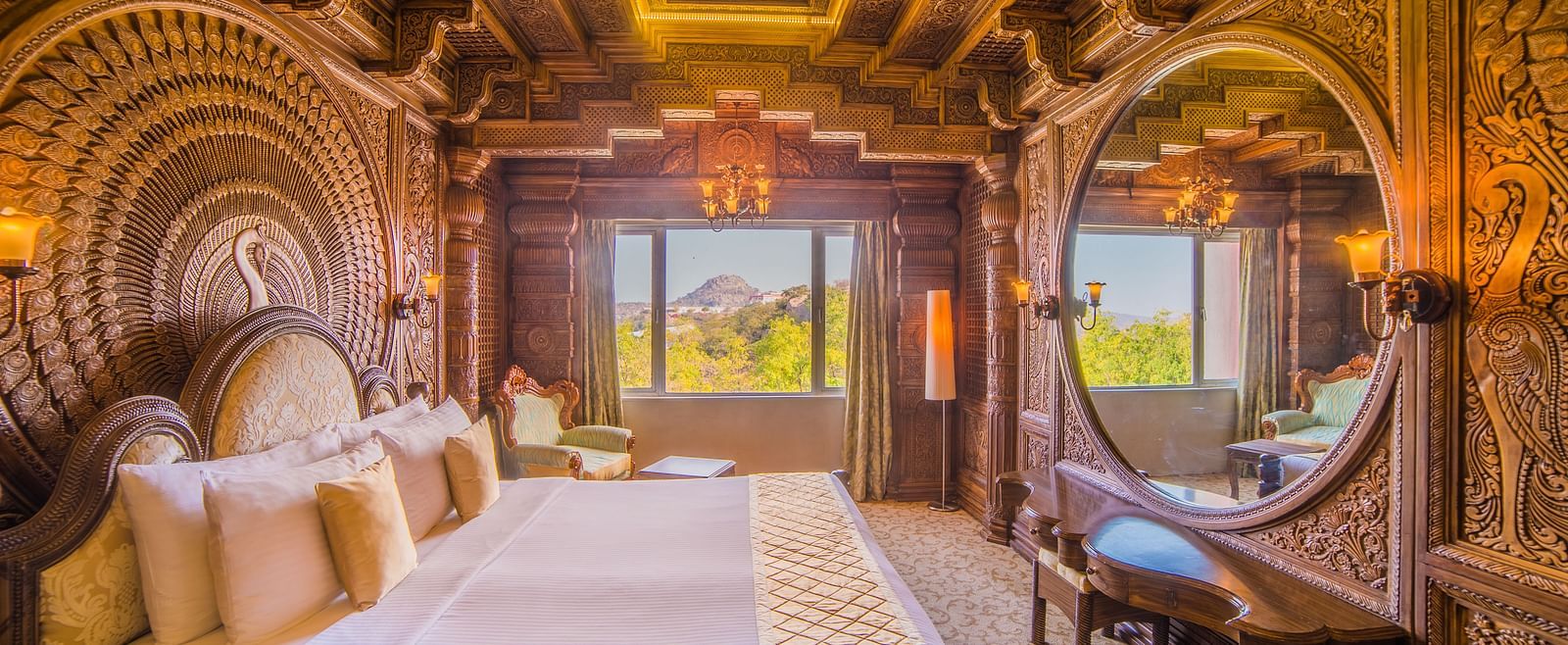 An intricately designed hotel room with traditional wood carvings and stunning views from the balcony at Sitara Luxury Hotel in Hyderabad near Ramoji Film City.