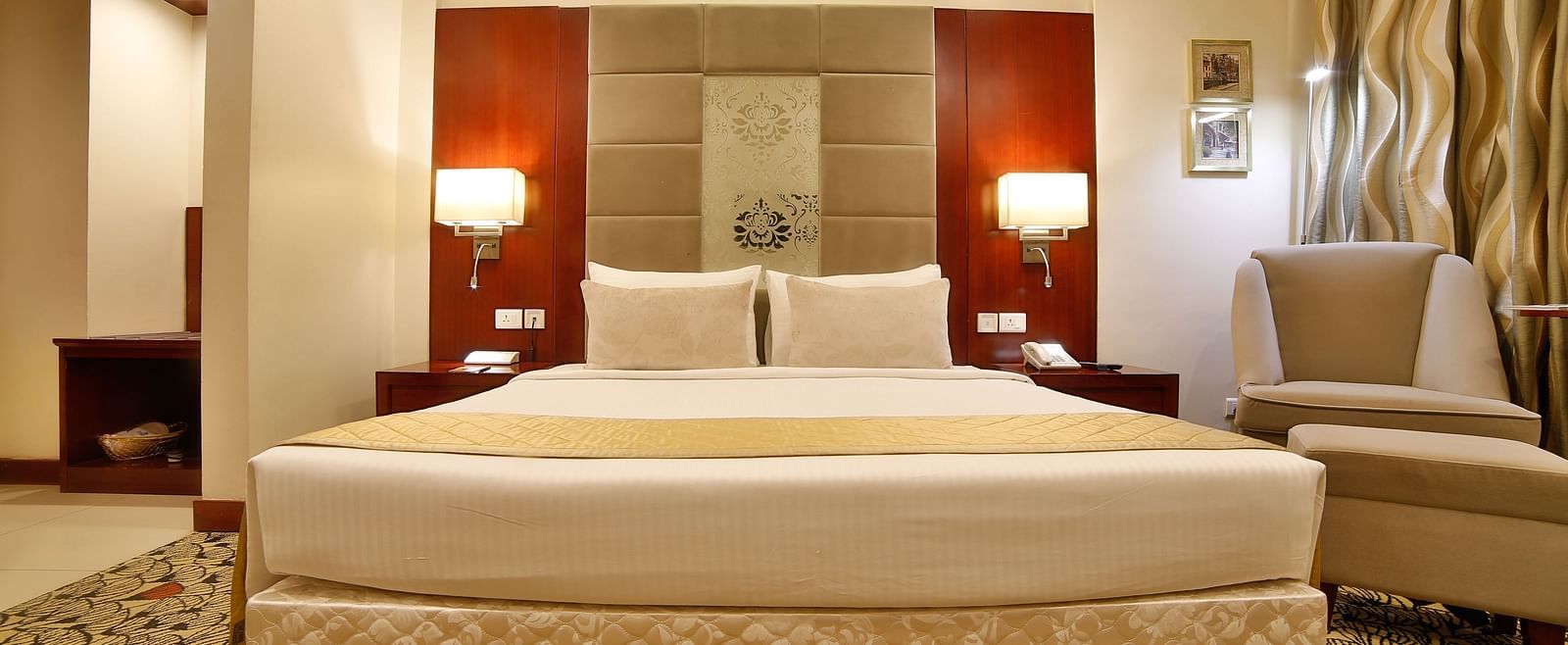 A sophisticated hotel bedroom with a large comfortable bed, modern amenities, and soft lighting A grand hotel suite with an opulent red and white decor, large bed, and seating area, reflecting a traditional style at Sitara Luxury Hotel in Hyderabad near Ra