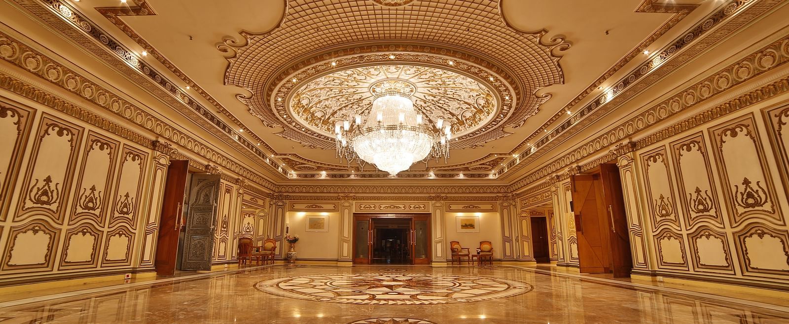  Interiors of Rang Mahal hall A grand hotel suite with an opulent red and white decor, large bed, and seating area, reflecting a traditional style at Sitara Luxury Hotel in Hyderabad near Ramoji Film City.