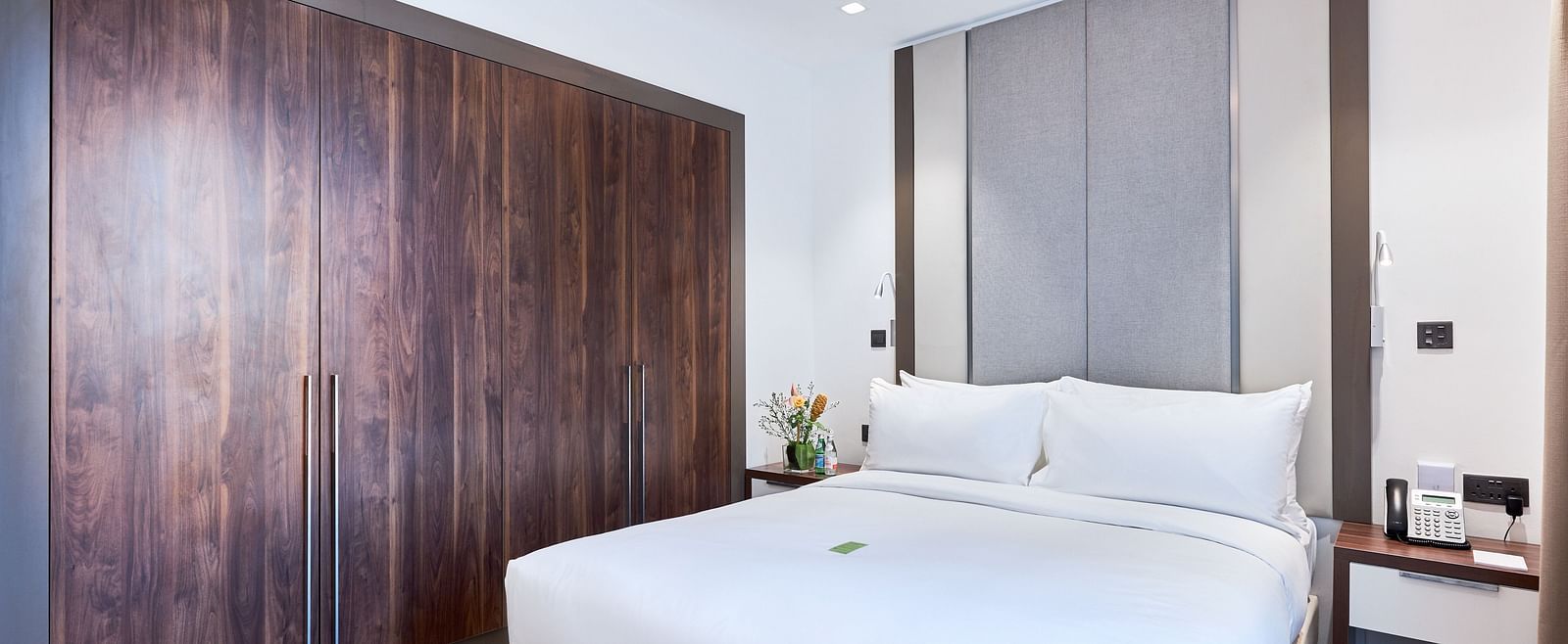 A view of large bed next to a wardrobe in Junior Suite at The Pelican Hotel, Accra.
