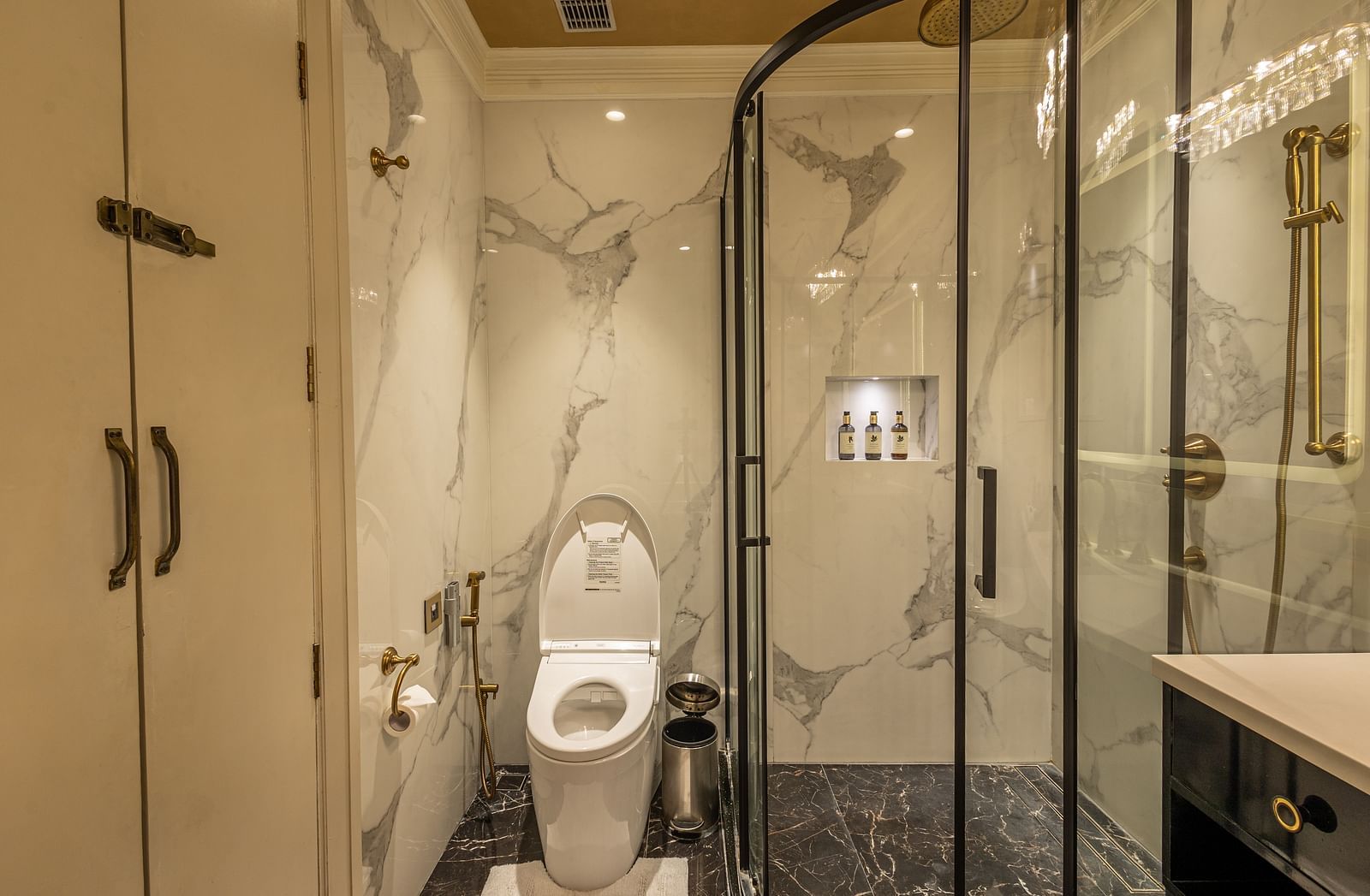 Washroom of the Executive Suite at The Claridges New Delhi, featuring a glass-enclosed bath area situated in the corner