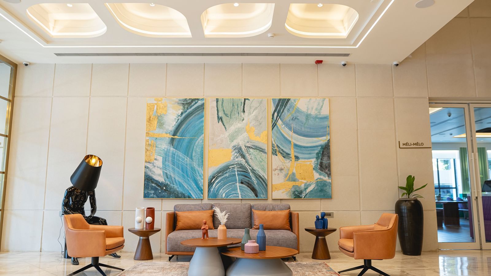 Lobby at KertelSuites, featuring a cosy sofa, a round coffee table, and an elegant ceiling with stylish lighting.