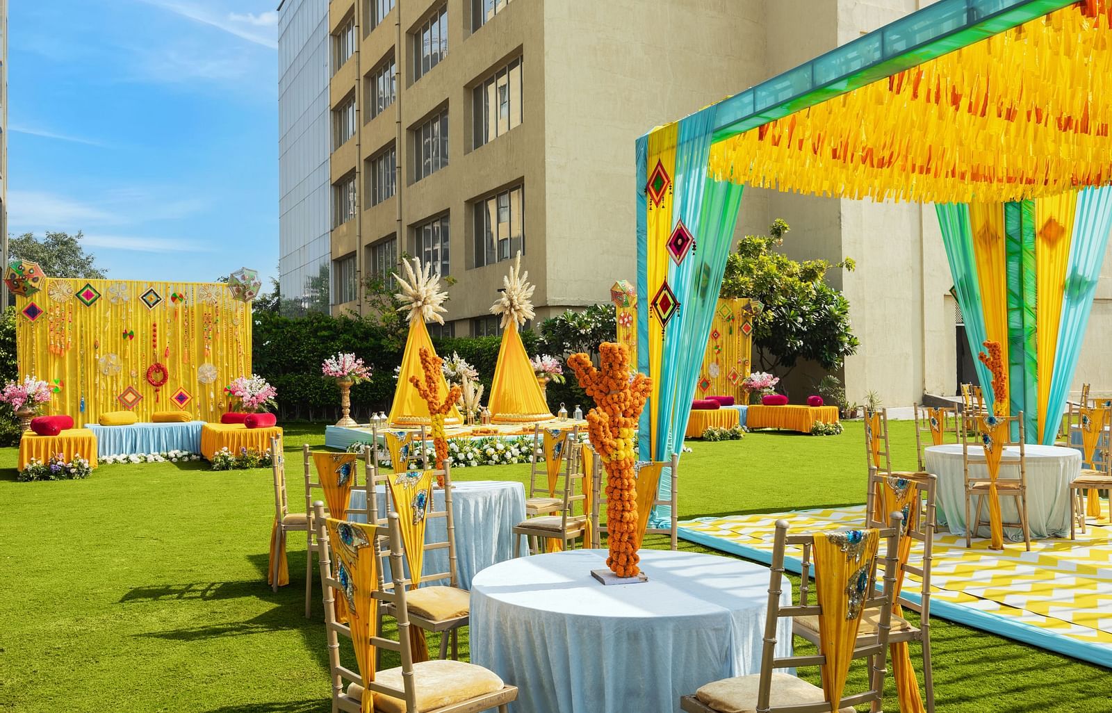 a view of an event space with tables and chairs in clusters and a canopy with tables underneath - The Hideaway Banquets & Lawns, Greater Noida