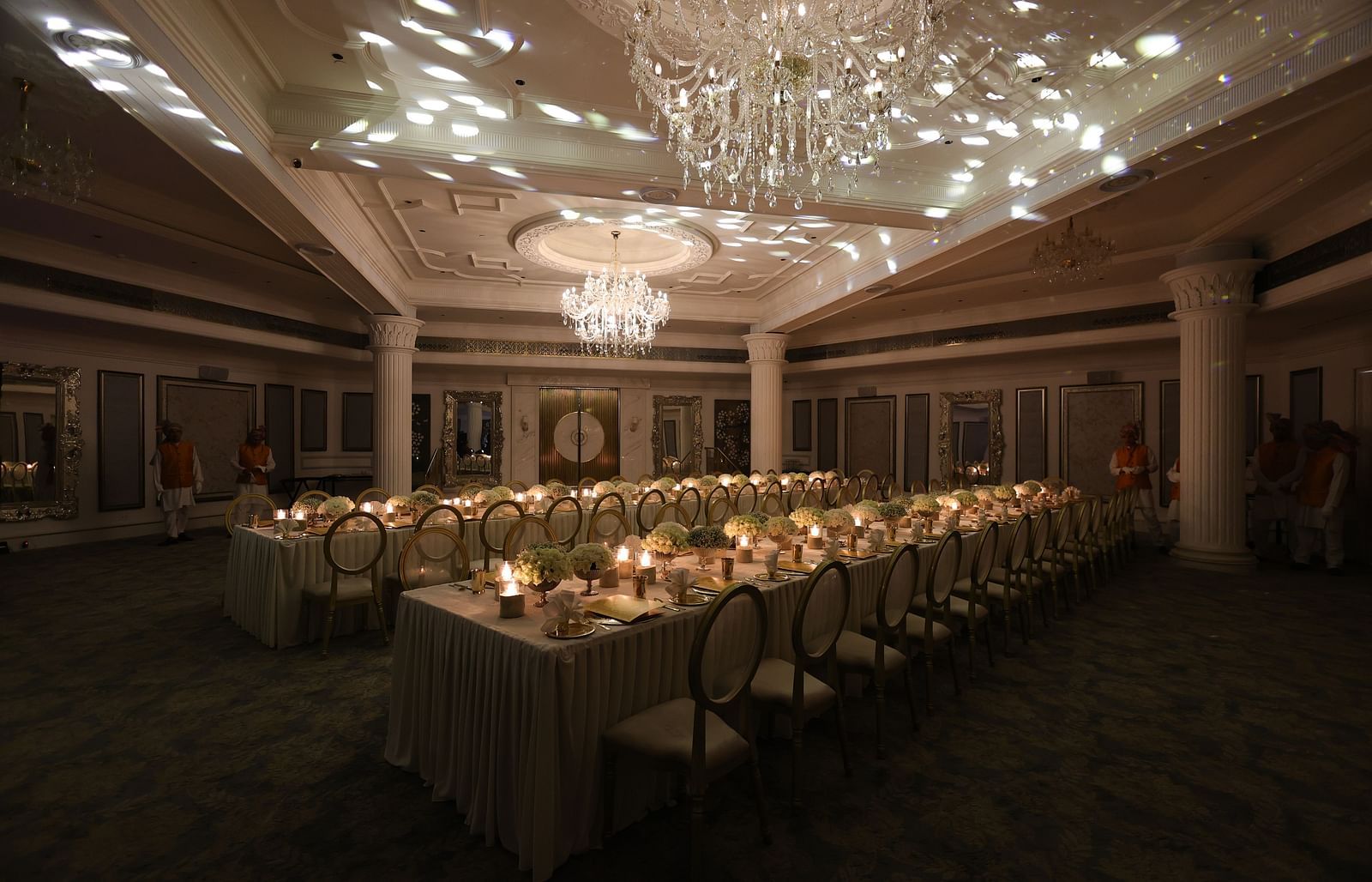 Elegant banquet setup with candlelit tables and a shimmering chandelier, creating a warm and sophisticated ambiance for events
