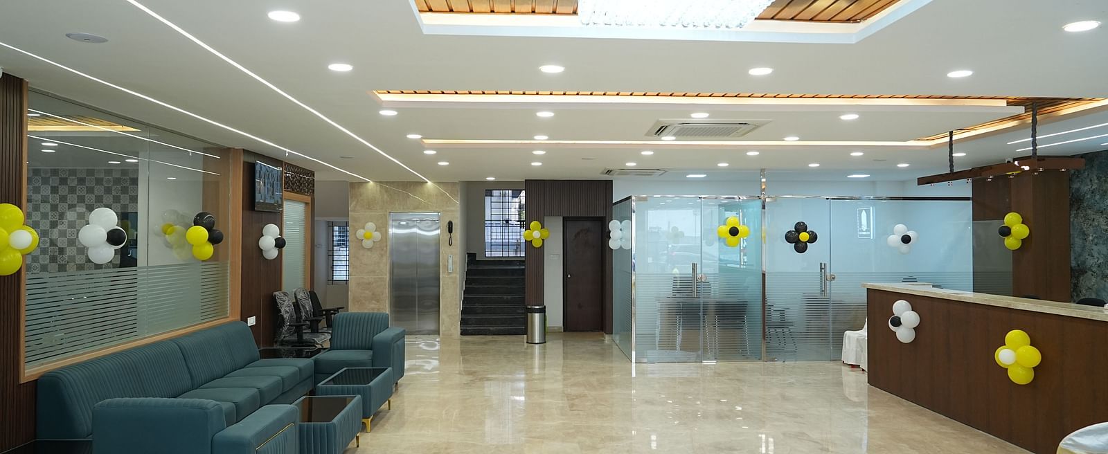 the expansive lobby with a teal coloured couch facing the reception desk - Hotel Grand Sigma