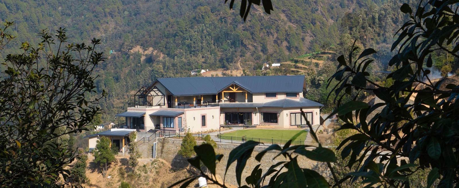View of The Chamomile Estate facade nestled in a lush hillside landscape.
