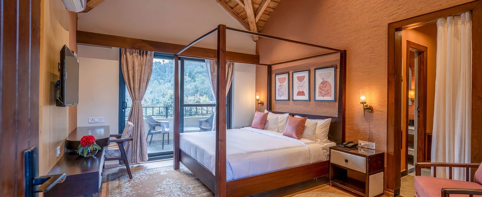 Bedroom with a four-poster bed and a view through large windows with curtains pulled to the sides at The Chamomile Estate.