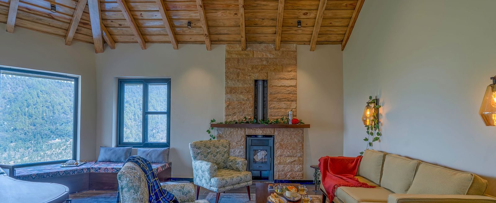 Living area with a fireplace, sofas, and a high, beamed ceiling at The Chamomile Estate.