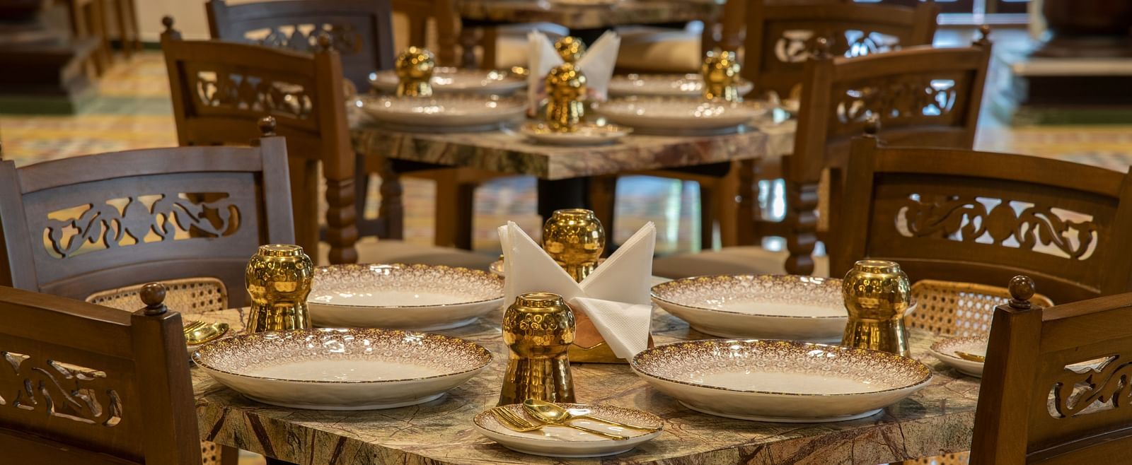  An image of dining area featuring chairs, plates on the table, and salt and pepper shakers - The President Hotel, Kumara Park, Bangalore