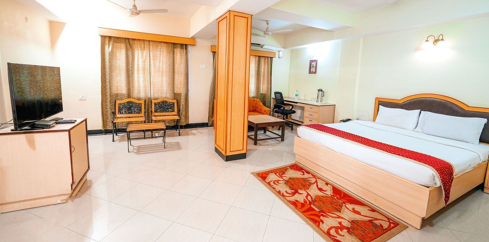 Room at Vasundhara Villa with a double bed and a television