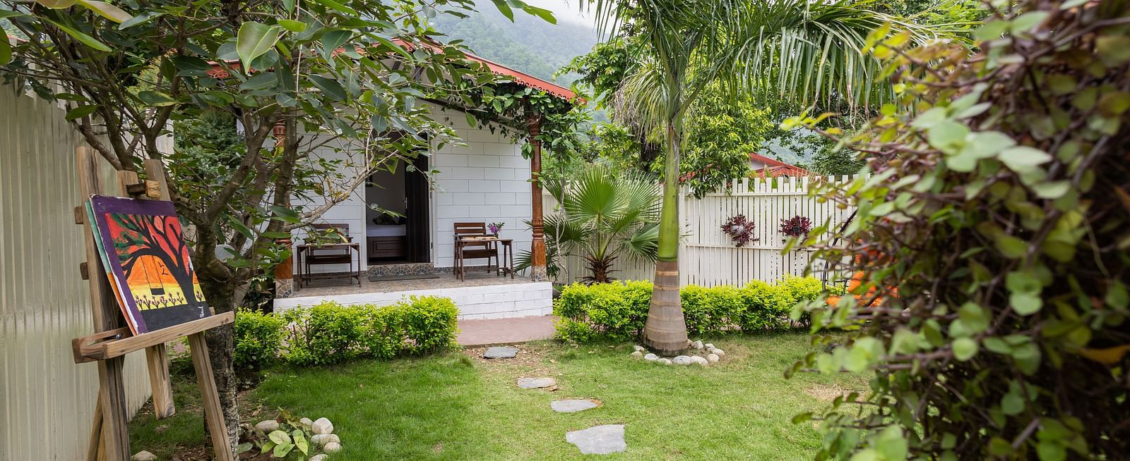 a stone pathway leading to a room on the grass - neer ganga resorts