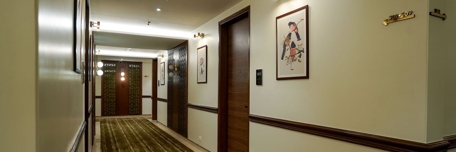 A wide angle shot of the dimly-lit corridor with several doors leading to the rooms at M2 Square by Monday Premium.