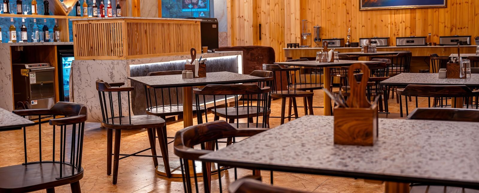 Image of the in-house restaurant featuring a fine dining setup, natural  lights and a coffee machine | The Tattva Devprayag
