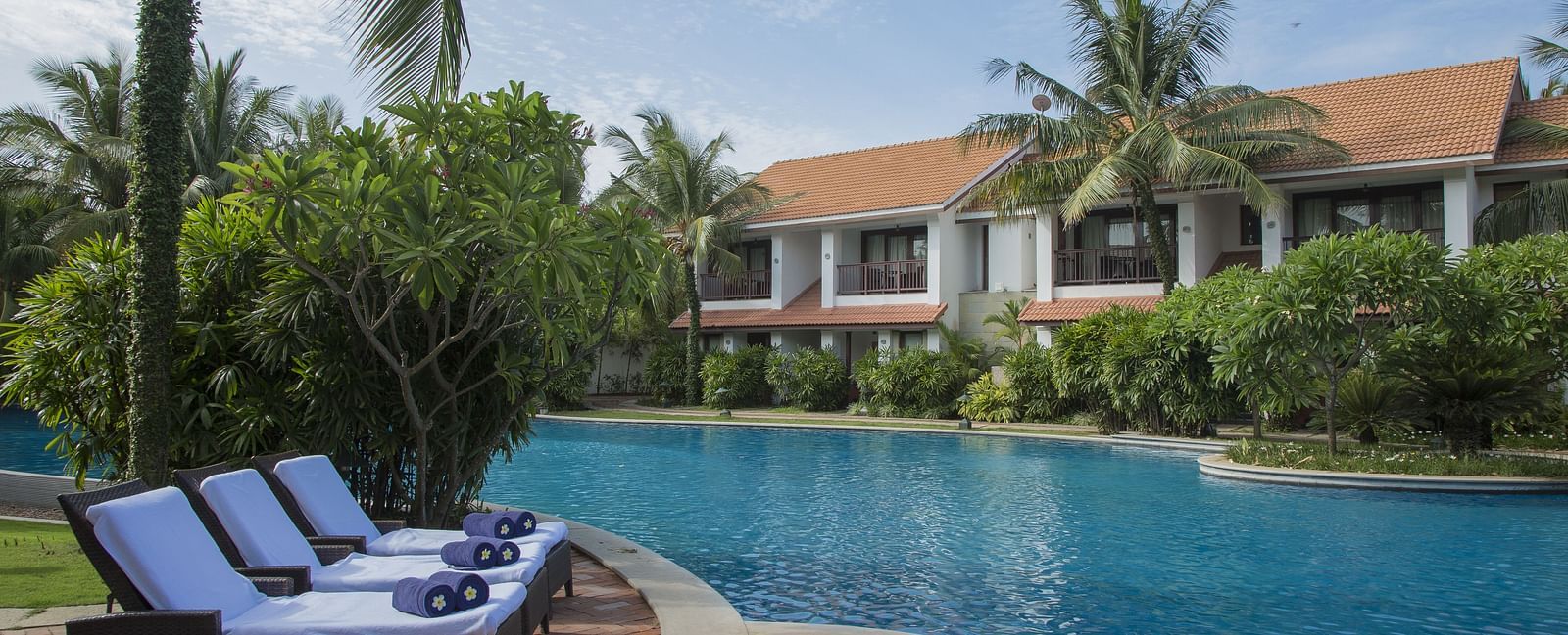Resort pool surrounded by palm trees and lounge chairs in a tropical setting at Radisson BLU