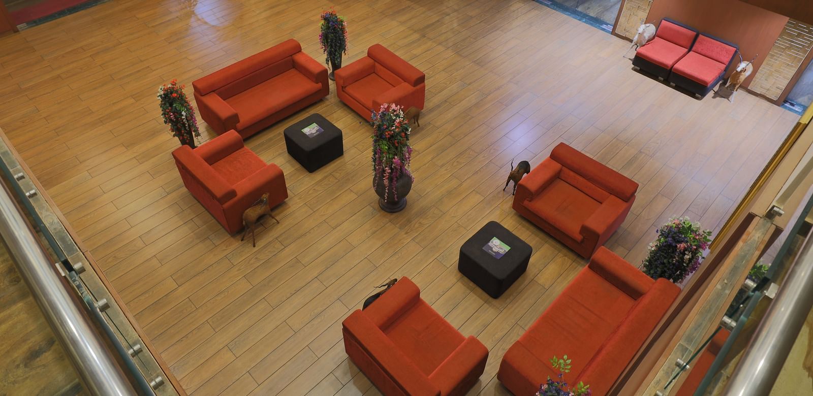 A top angle shot of the lobby at our hotel featuring the common seating area and wooden flooring - Vishal Lords Inn Gir Forest
