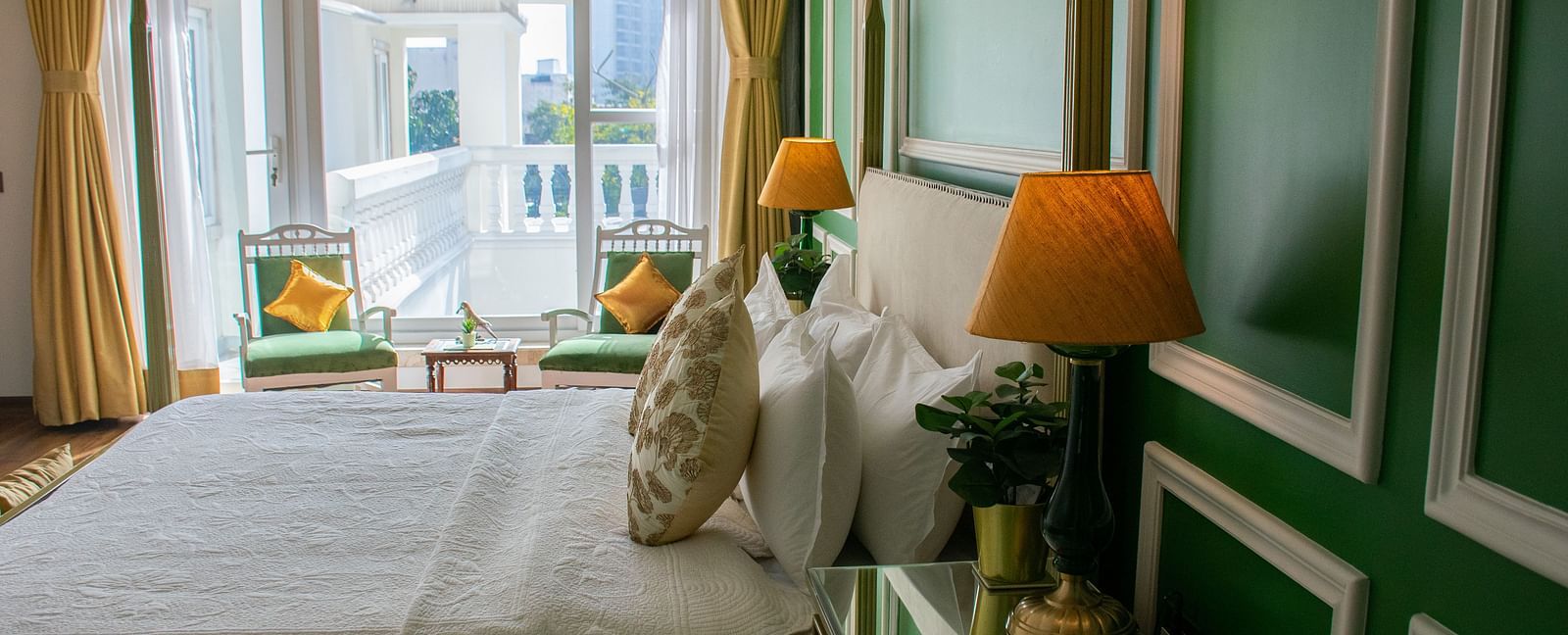 A room at Dileep Kothi, Jaipur with a double bed, side tables and a large window