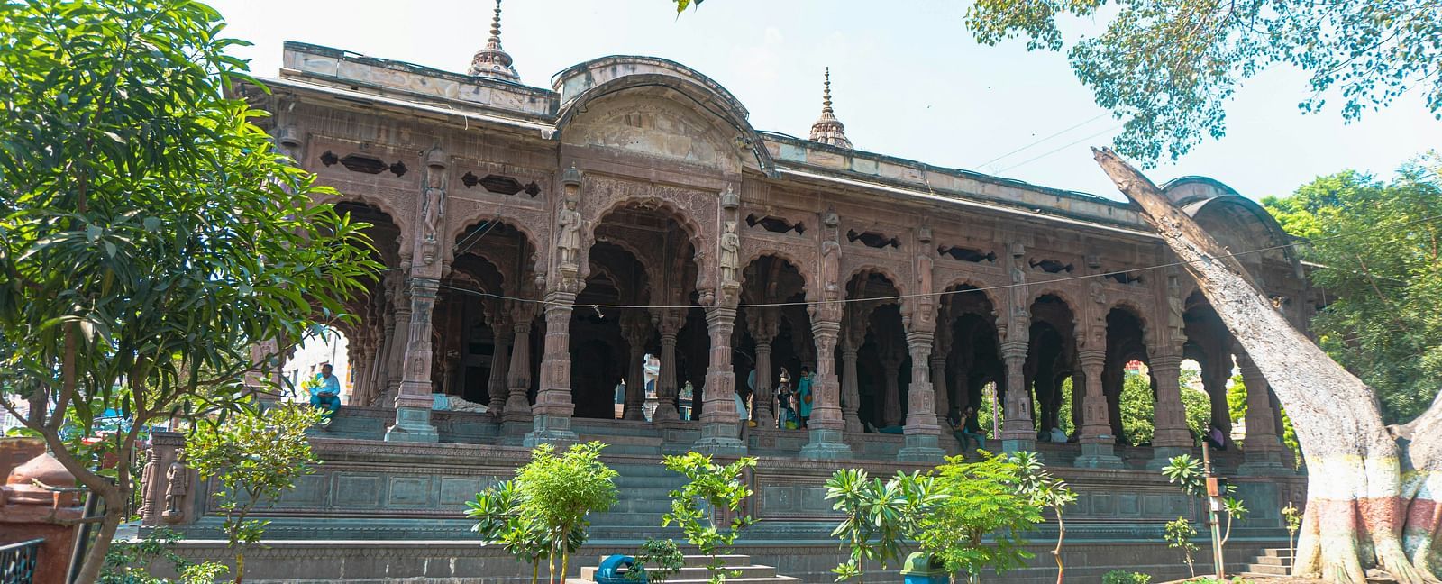 An overview of Rajwada palace in Indore with a garden and trees in front of it.