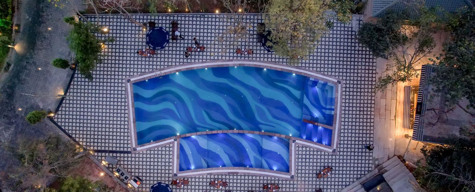 An aerial view of the swimming pool at Essentia Luxury Resort & Spa, Udaipur.