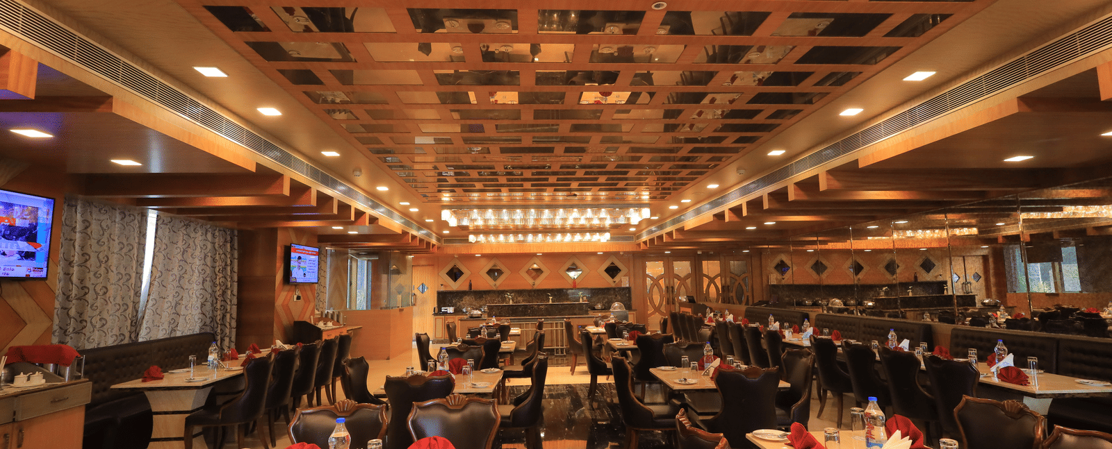 Full view of the Porchae multi-cuisine restaurant with warm lighting and well-arranged dining tables at Benzz Park, Vellore.