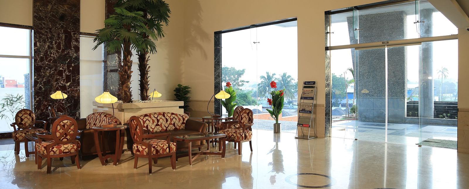 A spacious and elegant hotel lobby with natural lighting, cosy seating, and a welcoming reception area at Dhanalakshmi Srinivasan Hotels, Perambalur