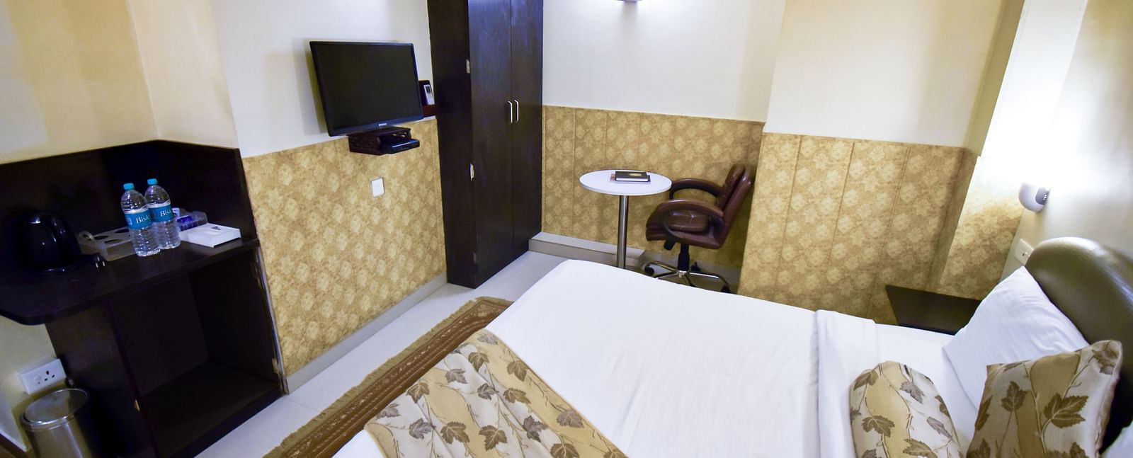 Side view from the bed of Economy Room featuring the television and a wardrobe. - Hotel Ashok Nagpur