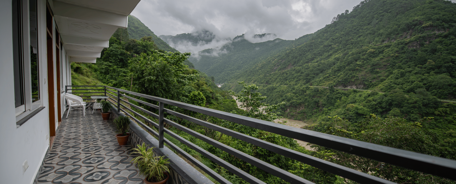 A balcony of the standard room at The Tattva Devaprayag with a view of the mountains and the river.