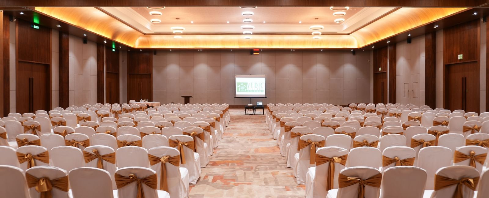Utsav Convention Centre with classroom-style seating and a presentation screen at Vedic Village Spa Resort.