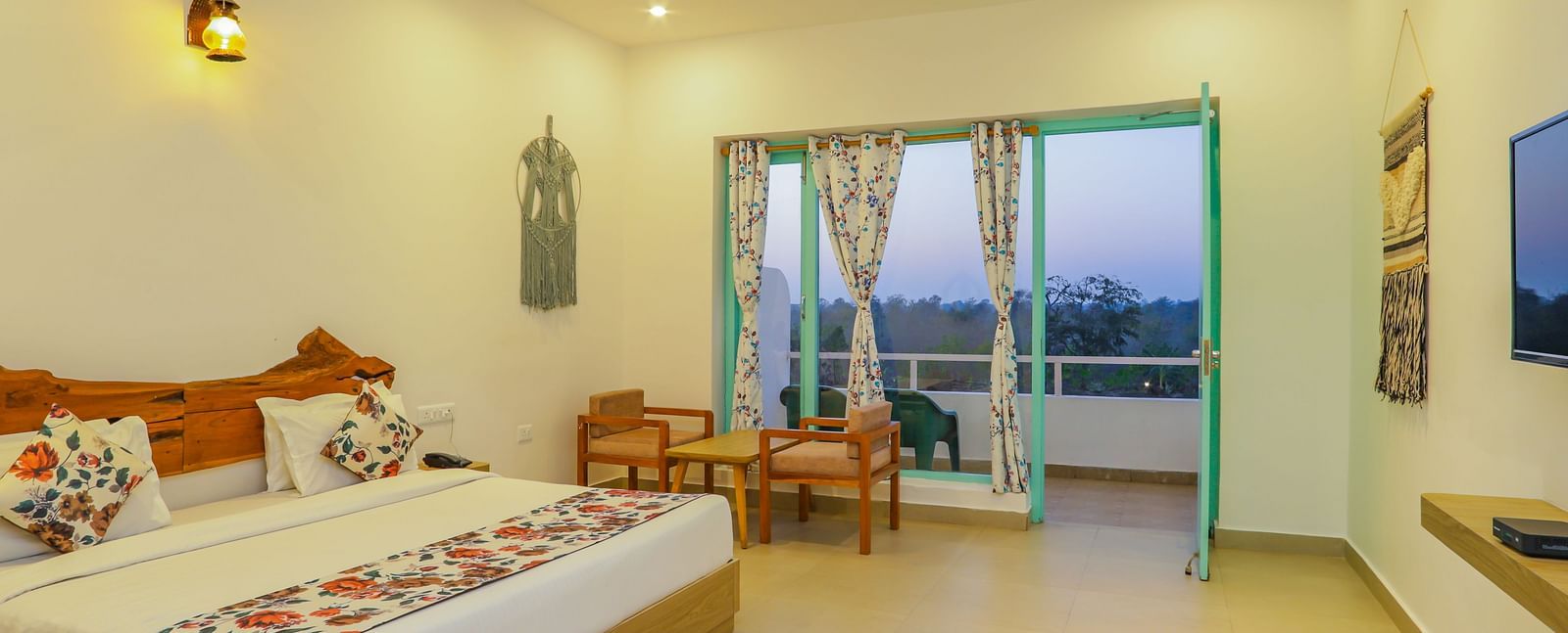 A comfortable bedroom at Vedikant Resorts The Mallard Corbett offers a bed, seating, and access to a balcony.