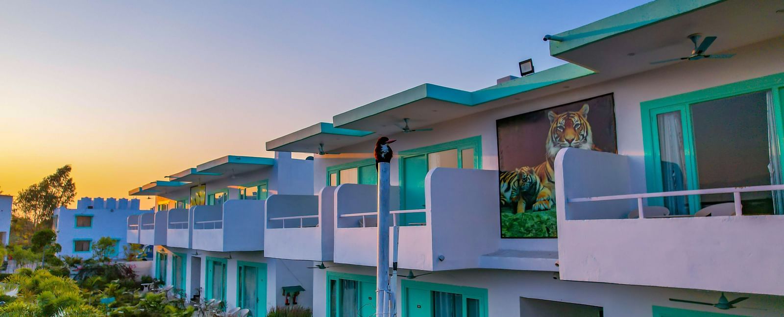 Side view of Vedikant Resorts The Mallard Corbett with balcony railings, garden space below, and a visible building façade.